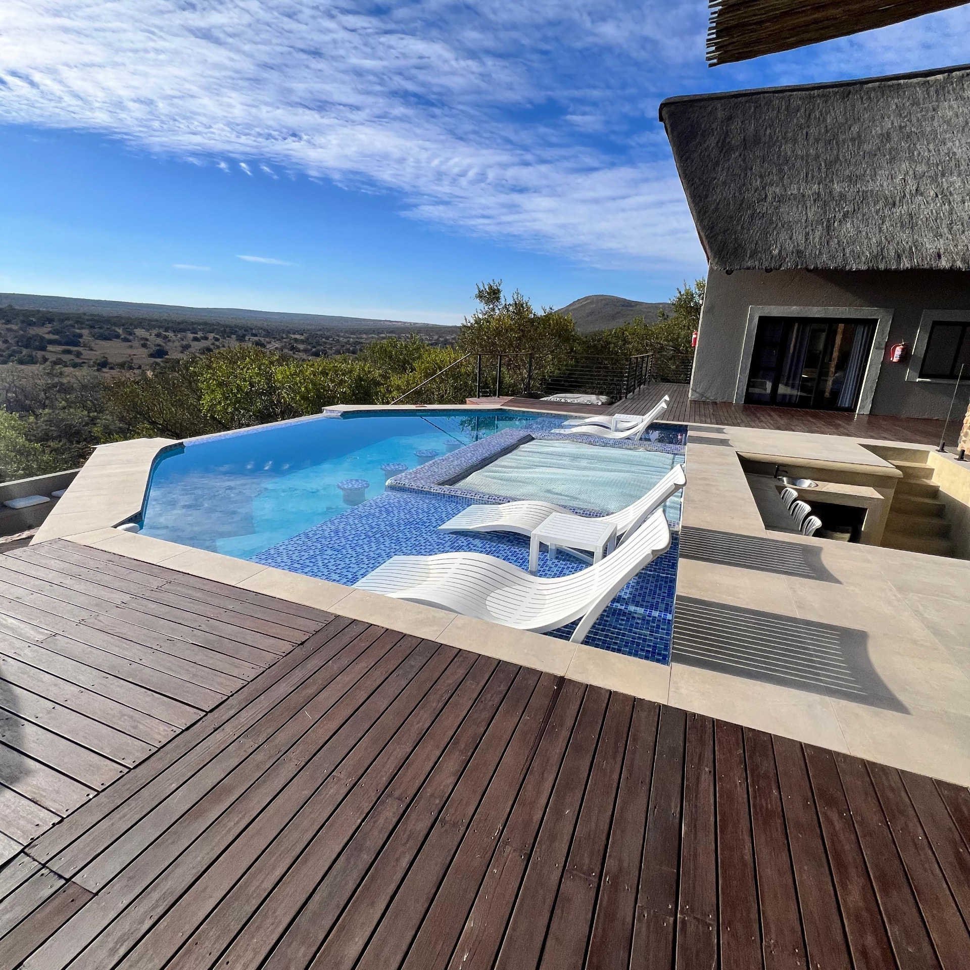 Timber deck, infinity pool and thatched roof of Tebuah Private Lodge above the Waterberg valley